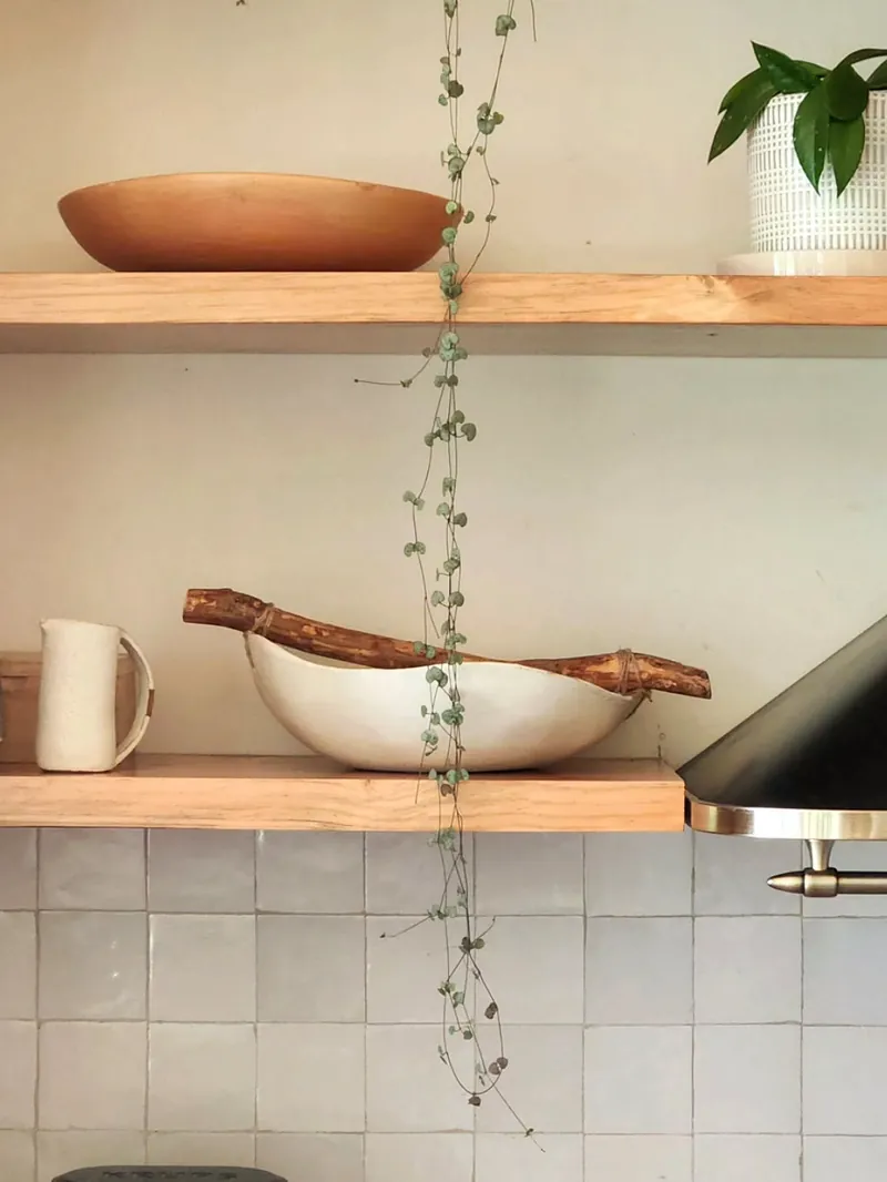 Fuente de gres blanca con asas de rama, en una repisa de cocina