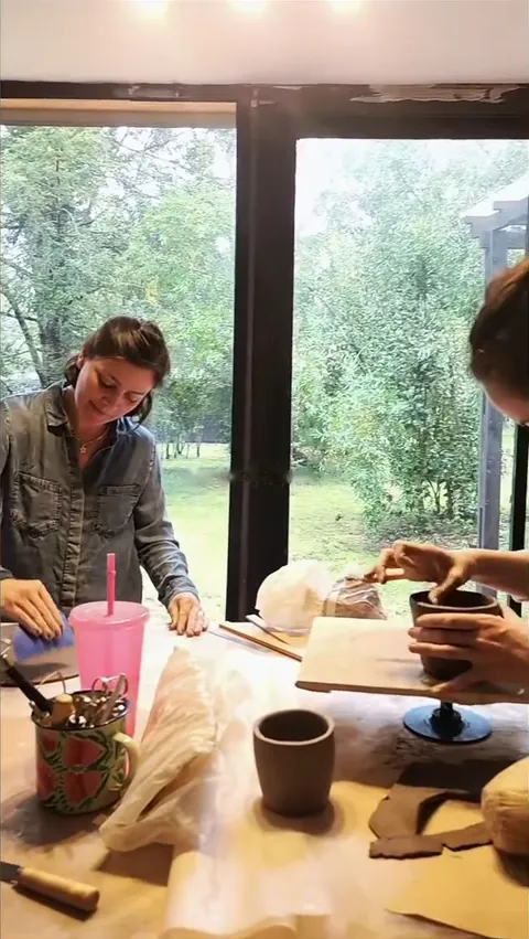 Clase de cerámica en el taller, con el bosque en la ventana
