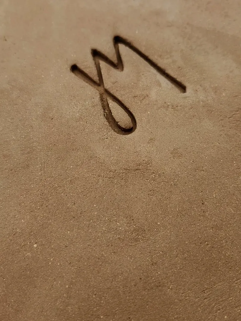 La firma JM de Josefina tallada en el barro