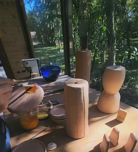 Piezas de gres enceradas en la base, sobre la mesa del taller