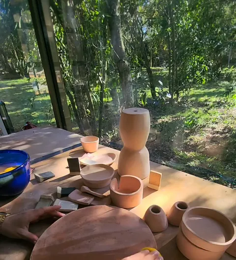 Mano limpiando un plato de gres con una esponja